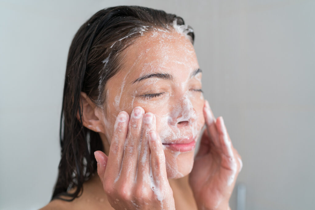 Woman washes face with Top Facial Cleanser